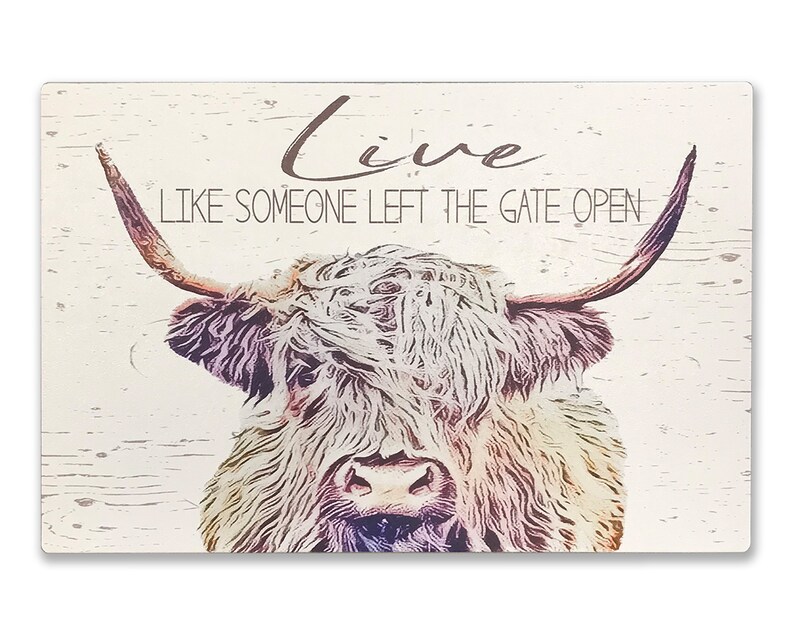 Op de afbeelding: Rechthoekig houten bord met een illustratie van een Schotse Hooglander. De tekst "Live Like Someone Left The Gate Open" staat op het bord. De koe heeft lange hoorns en een ruige vacht. Lichte houtnerf achtergrond.