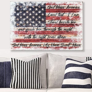 May include: A distressed wood American flag with the words "God Bless America, Land That I Love, Stand Beside Her, And Guide Her Through The Night With The Light From Above, God Bless America My Home Sweet Home" written on it.