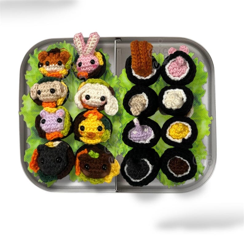 K&ouml;nnte beinhalten: Eine Metall-Lunchbox gef&uuml;llt mit geh&auml;keltem Sushi und tierf&ouml;rmigen Lebensmitteln. Die Sushi-Rollen haben verschiedene F&uuml;llungen, w&auml;hrend die tierf&ouml;rmigen Lebensmittel ein Kaninchen, einen B&auml;ren und andere Kreaturen umfassen. Das Essen ist auf einem Bett aus gr&uuml;nem Salat angeordnet.