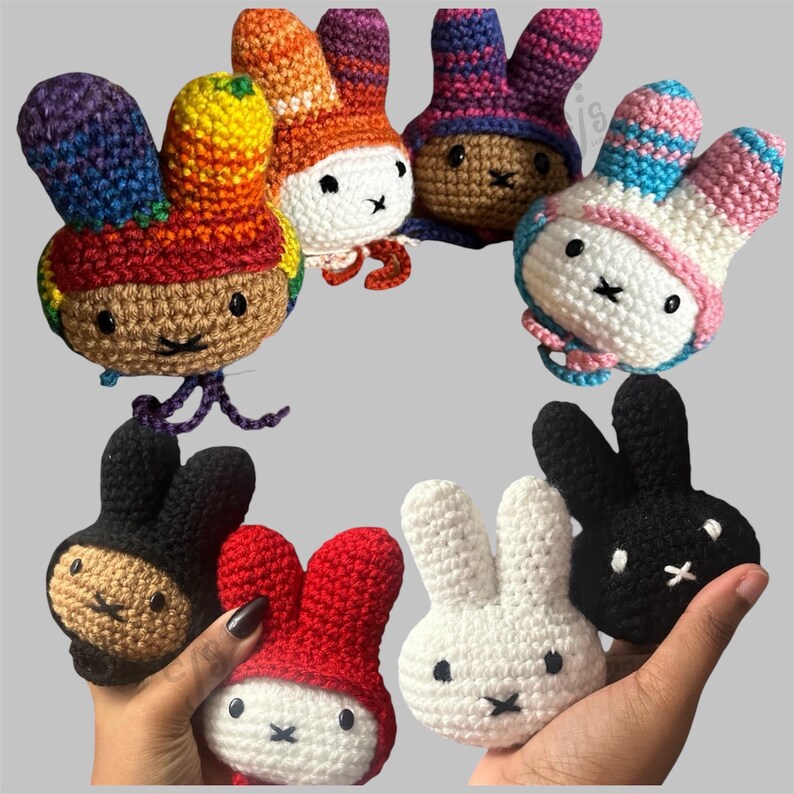 May include: A collection of eight small, handmade crochet rabbit heads featuring various colour combinations, including solid white, solid black, solid red, and multi-coloured patterns. Each rabbit head has two upright ears, black eyes, and a stitched mouth.