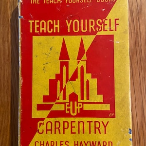 May include: A vintage Teach Yourself book cover in red and yellow. The book is titled "Teach Yourself Carpentry" and features a stylised illustration of a house with the word "EUP" below it. The author is Charles Hayward.