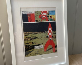 Lámina decorativa enmarcada con una página de la revista Tintín, con opción de elegir la página interior, ideal para la habitación de los niños o como regalo para coleccionistas de Hergé.