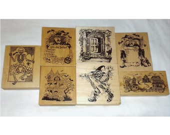 May include: A collection of wooden stamps with Halloween-themed designs. The stamps feature images of a skeleton, haunted houses, a witch, and a spooky doorway. Some stamps include text such as "You are Invited".