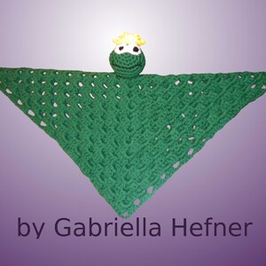 May include: Green crocheted baby blanket with a green frog attached. The frog has a yellow crown and white eyes.