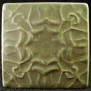 May include: Square, olive-green ceramic tile with a raised, organic pattern. The design features flowing, interconnected shapes that create a textured surface. The tile has rounded edges and a matte finish, suitable for home decor or craft projects.