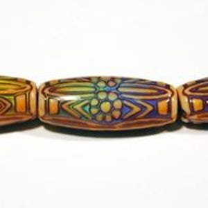 May include: Three cylindrical beads arranged horizontally, each featuring a tan base colour with intricate, raised dark brown outlines forming floral and geometric patterns. The beads display a gradient of yellow, green, and purple hues.