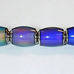 May include: A close-up of a multi-colored glass bead necklace. The beads are iridescent and have a blue, purple, and green color scheme. The beads are separated by silver spacers.