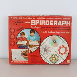 May include: Vintage Kenner's New Spirograph box. The red box features the Spirograph logo and illustrations of children using the toy. The box also shows examples of the patterns that can be created with the Spirograph.