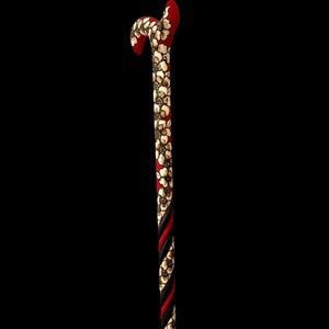Puede incluir: Un bast&oacute;n de madera con un dise&ntilde;o de espiral rojo y negro y detalles florales blancos.