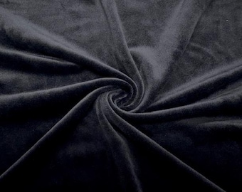 May include: Close-up of a dark navy blue velvet fabric. The fabric is swirled in a spiral pattern, with deep shadows and highlights emphasizing the soft texture. The material appears plush and luxurious.