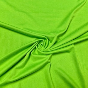 May include: A bright green fabric with a smooth texture. The fabric is folded and draped, showing its soft and flowing nature.