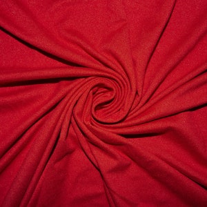 May include: A close-up of a red fabric with a swirling pattern. The fabric is smooth and has a subtle sheen.