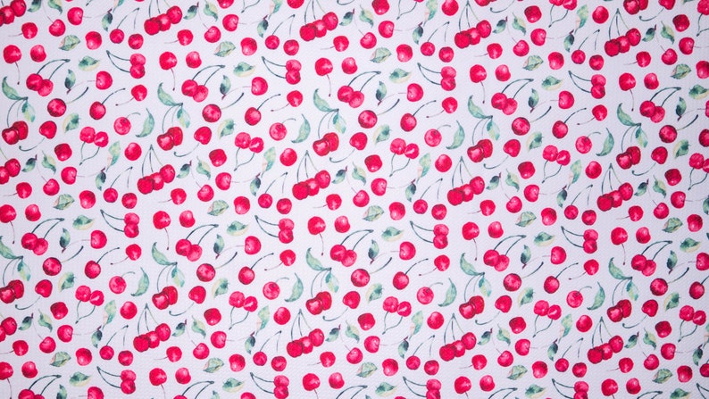 Puede incluir: Tela blanca con un patr&oacute;n repetido de cerezas rojas y hojas verdes. Las cerezas est&aacute;n agrupadas y dispersas por la superficie, creando un dise&ntilde;o vibrante. Adecuado para diversos proyectos de manualidades y costura.