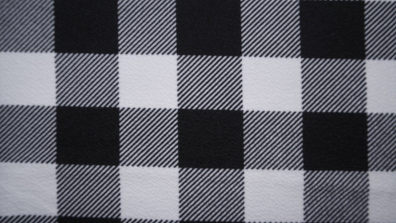 May include: Black and white checkered fabric with a subtle diagonal pattern. The fabric has a smooth, slightly textured surface.
