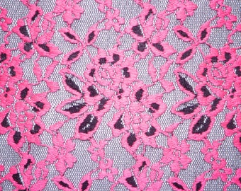 May include: Pink lace fabric with a floral pattern. The lace is delicate and intricate, with a black outline.