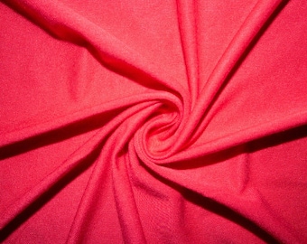 Puede incluir: Primer plano de una tela de color rosa brillante con un patrón de espiral. La tela es suave y lisa, con un brillo sutil.