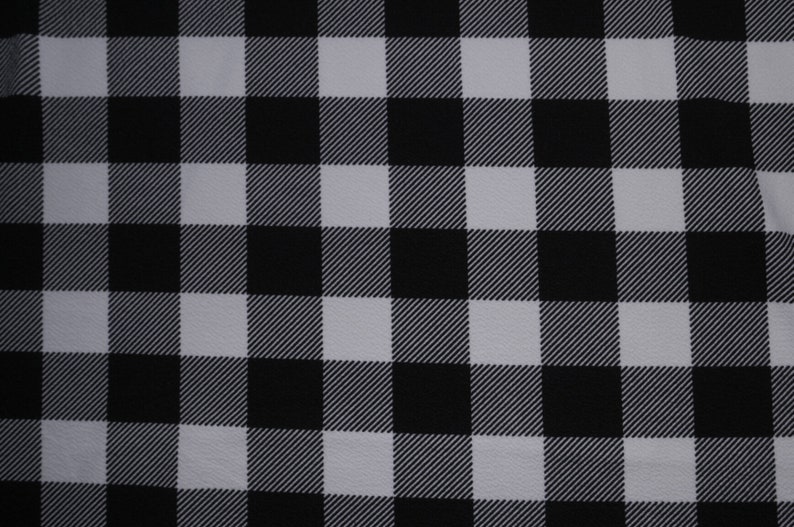 May include: Black and white checkered fabric with a subtle diagonal pattern. The fabric has a smooth texture.