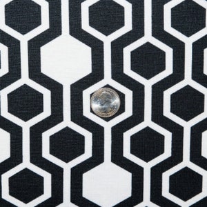 May include: Black and white geometric fabric with a repeating hexagonal pattern. The fabric has a textured surface.