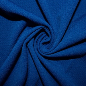 May include: A close-up of a deep blue fabric with a swirling pattern. The fabric is soft and textured, creating a sense of depth and dimension.