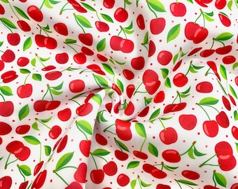 May include: White fabric with a repeating pattern of bright red cherries, green leaves, and small pink dots. The cherries have a glossy appearance, and the leaves are a vibrant green. The fabric is slightly wrinkled, creating depth.