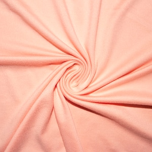 May include: A close-up of a peach-colored fabric with a swirling pattern. The fabric is soft and smooth, with a subtle sheen.
