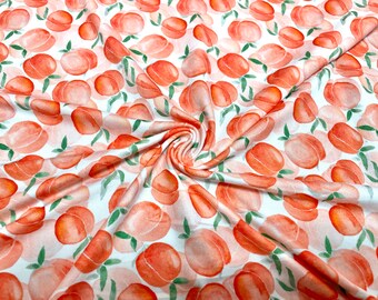 May include: White fabric with a repeating pattern of watercolor peaches in shades of orange and pink. Green leaves are interspersed among the peaches. The fabric is folded, creating soft shadows and texture.
