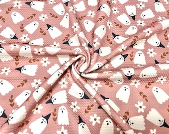 May include: Pink fabric with a white ghost and flower pattern. The ghosts are wearing witch hats and have a smiling face.