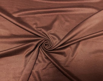 Könnte beinhalten: Eine Nahaufnahme eines braunen Stoffes mit einer glatten, weichen Textur. Der Stoff ist gefaltet und drapiert und zeigt seinen Fall und seine Fließfähigkeit.