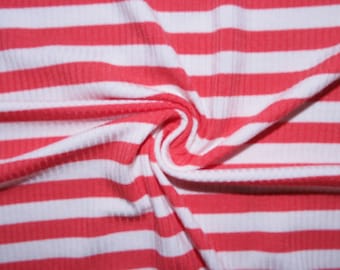 Puede incluir: Una tela acanalada con un patrón repetitivo de rayas horizontales en rojo coral vibrante y blanco nítido. El material está fruncido en el centro, creando pliegues y sombras suaves que resaltan la superficie texturizada y lineal de la tela.