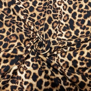 May include: Brown and black leopard print fabric with a textured surface.