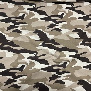 May include: A close-up of a fabric with a camouflage pattern in shades of brown, black, and white.