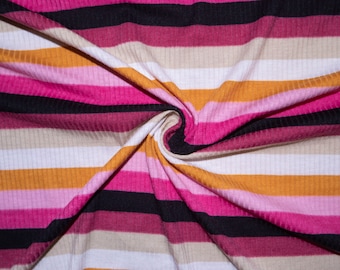 Puede incluir: Primer plano de una tela a rayas con bandas alternas de rosa, blanco, beige, naranja y negro. La tela está doblada y retorcida, creando un patrón de remolino.