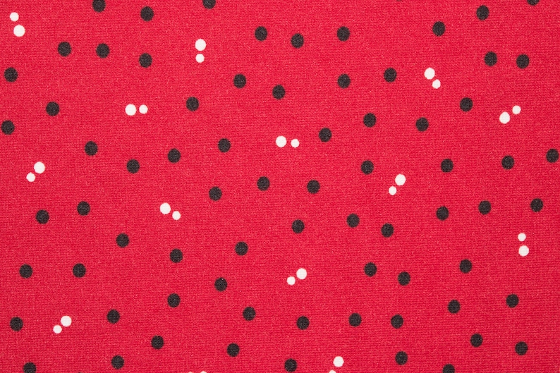 Puede incluir: Tela roja con un patr&oacute;n repetitivo de lunares negros y blancos.