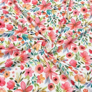 Pode incluir: Tecido branco com um padrão floral vibrante. O design apresenta flores rosa, coral e laranja com folhas verdes e azuis. O tecido é densamente coberto com vários tipos de flores.