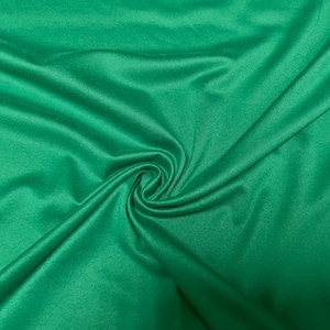 May include: A smooth, emerald green fabric with a soft, silky texture. The fabric is draped and folded, showcasing its flowing nature.