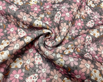 May include: Pink and white ghost and flower pattern on a grey fabric. The fabric has a distressed look.