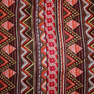 May include: Close-up of a fabric with a repeating pattern of vertical stripes. The design features zigzags, diamonds, and floral elements in red, orange, white, and brown hues. The overall aesthetic is reminiscent of tribal or ethnic textiles.