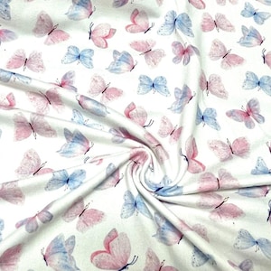May include: White fabric featuring a repeating pattern of pink and blue watercolour butterflies. The butterflies are spread across the fabric, creating a delicate and whimsical design. The fabric is soft and flowing, suitable for various craft projects.