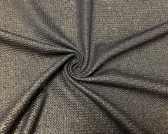 May include: Black fabric with a gold metallic sheen. The fabric has a textured, woven pattern.
