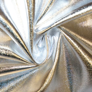 May include: Silver metallic fabric with a wrinkled, crinkled texture. The fabric has a subtle sheen and a smooth, silky feel.