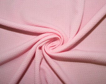 May include: A close-up of a pink textured fabric. The fabric is soft and has a subtle sheen.
