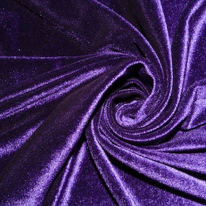 May include: A close-up of a deep purple velvet fabric with a swirling pattern. The fabric is soft and luxurious, with a subtle sheen.