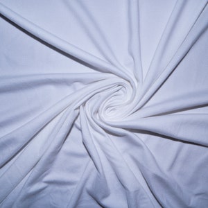 May include: White fabric background with a swirling pattern created by the folds of the fabric.