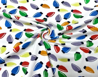 May include: White fabric with a repeating pattern of colourful light bulbs. The light bulbs are in various colours, including red, green, blue, yellow, and purple.