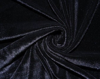 May include: Close-up of a black velvet fabric with a soft, smooth texture. The fabric is draped and folded, creating a swirling pattern.