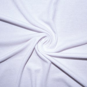 May include: Close-up of white ribbed fabric, swirled in a spiral pattern. The fabric is tightly woven, with visible vertical lines. The texture appears soft and smooth, with subtle shadows adding depth. The overall effect is clean and minimalist.