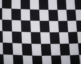 May include: A close-up of a fabric with a black and white checkerboard pattern. The squares are evenly sized and arranged in a grid. The fabric appears to be smooth and possibly made of cotton or a similar material.