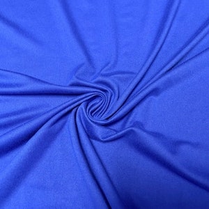 May include: Close-up of a vibrant royal blue fabric with a soft texture. The fabric is gathered in a spiral, creating a swirling pattern. The material appears to be lightweight and flowing, with subtle variations in the color.
