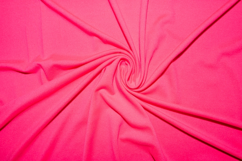May include: A close-up of a bright pink fabric with a swirling pattern. The fabric is smooth and soft, with a slight sheen.