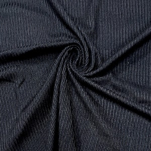 May include: Close-up of a dark blue ribbed fabric with a subtle sheen. The fabric is wrinkled and folded, showing its texture.